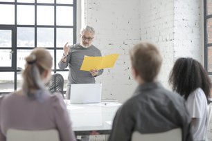 Mann vor Publikum sprechend