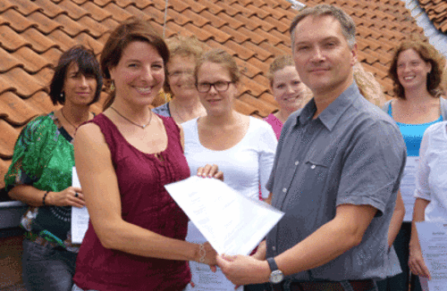 Dipl.-Psychologe Uwe Langnickel überreicht das Abschlusszertifikat an die Pädagogin Natascha Hanß